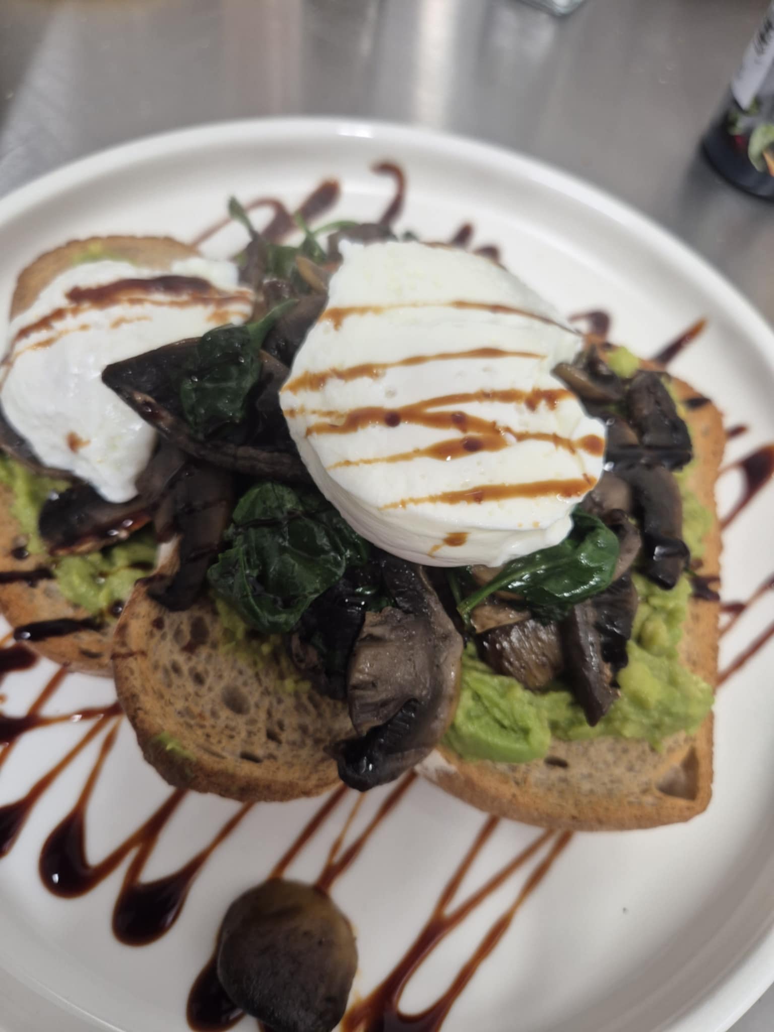 Smashed avocado toast with egg and greens